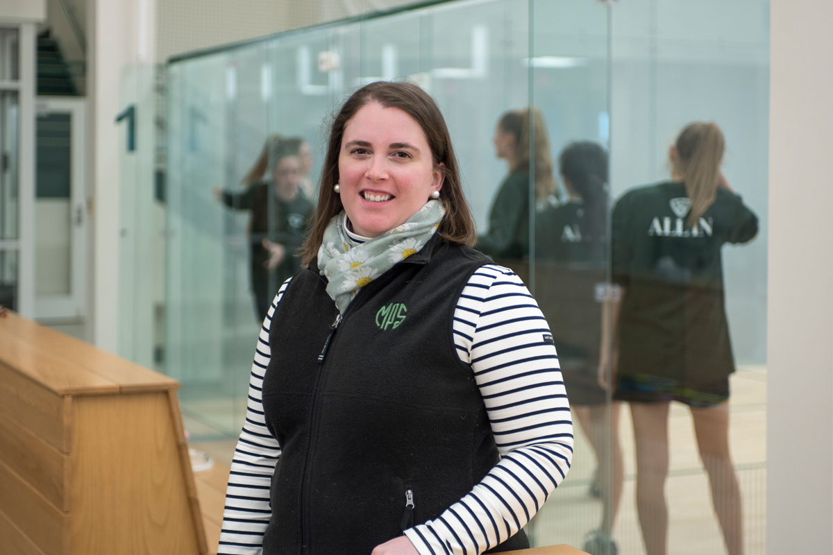 Coach Sarah Odell standing in front of squash courts at Exeter