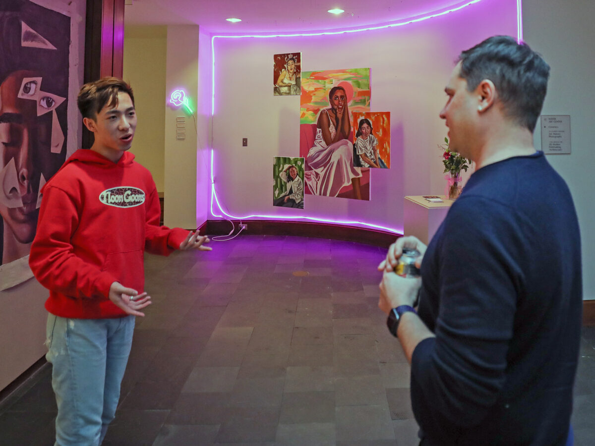 Justin Li and M. Sharkey discuss Li's artwork in the foyer of the Lamont Gallery.