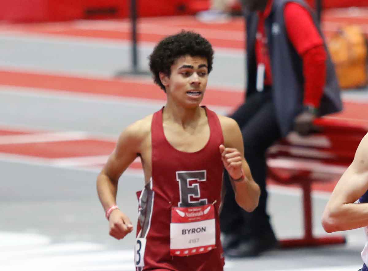 A runner on a track in Exeter red.