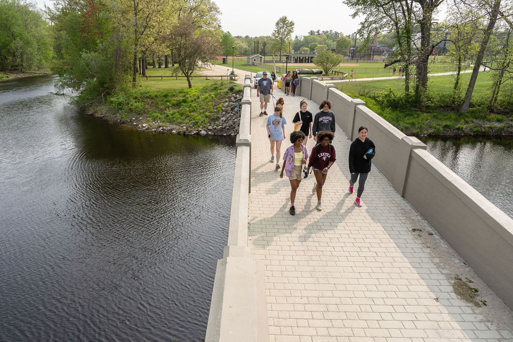 Group of students walking across a bridge.