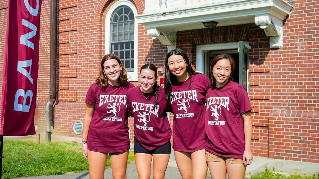 Group of girls in matching Orientation t-shirts standing in front of dorm