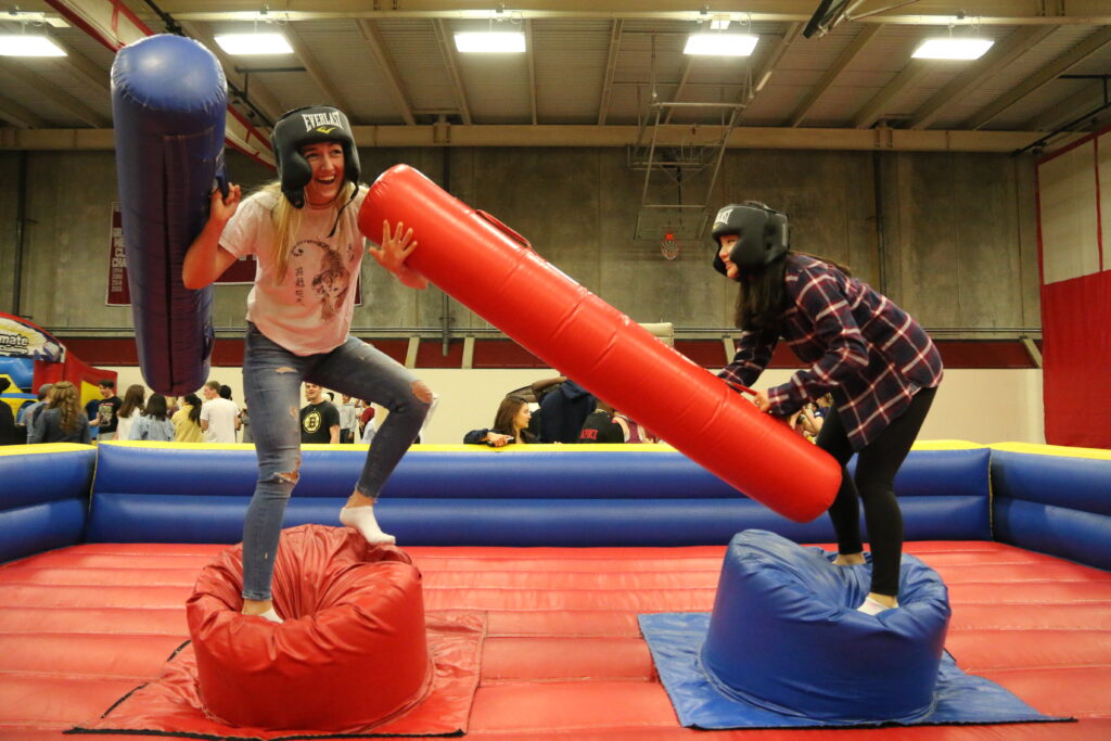 Two students stand on inflatable stands.