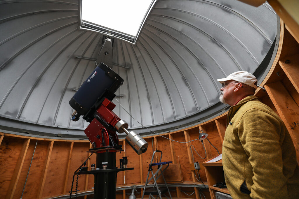 Professor John Blackwell stands next to telescope in the Grainger Observatory