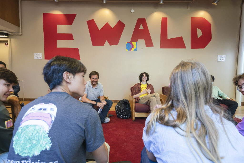 Students sit in circle in dorm common area