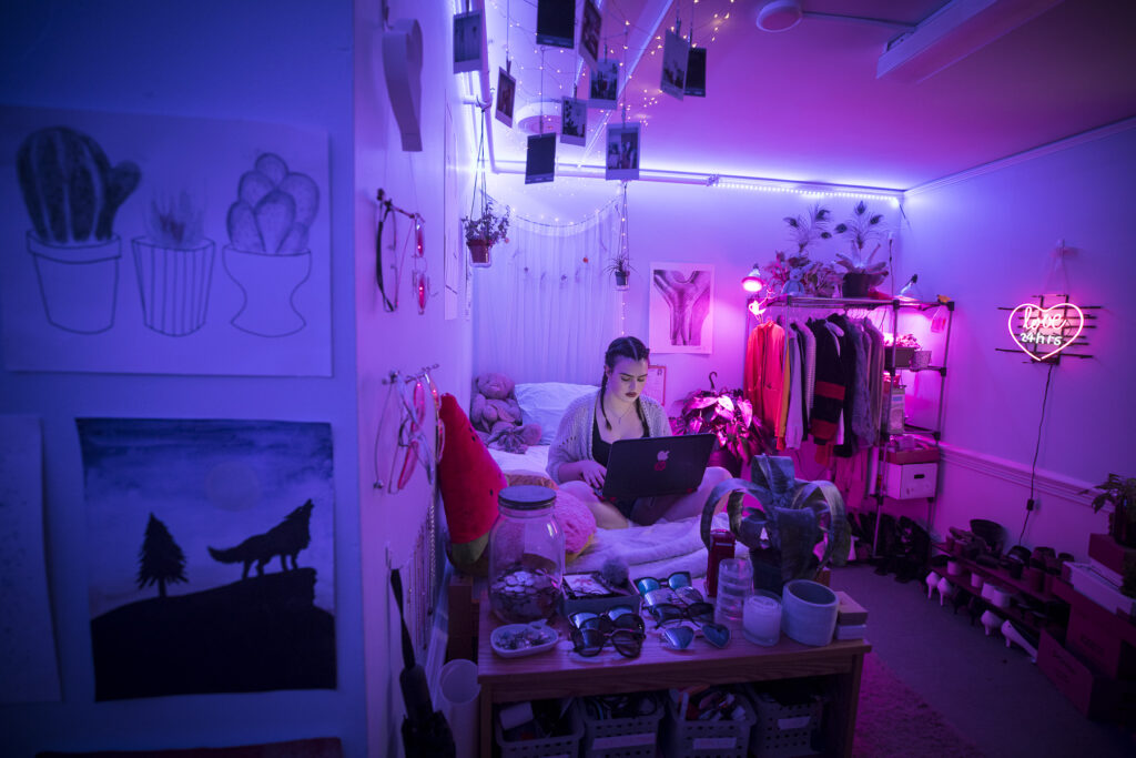 Girl sits in dorm room with purple neon lights