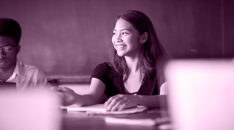 Exeter student seated at a Harkness table and smiling