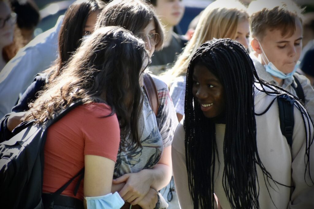 Two students stand together and laugh