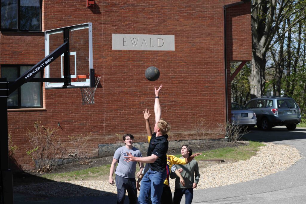 Group of boys playing basketball in front of dorm