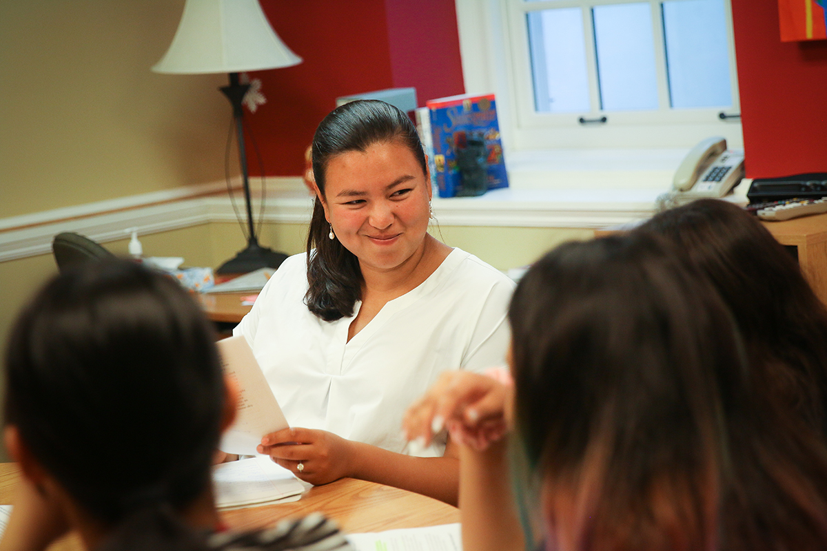 Instructor Jocelyn Bohn interacts with her students around the Harkness table