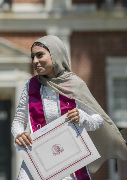 Student walks off graduation stage holding diploma