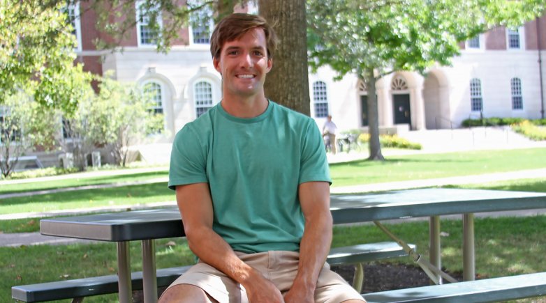 Tyler sitting at a picnic table on campus.