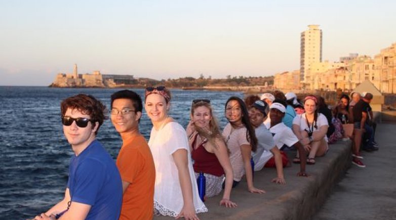 Students sitting on the Malecón looking over the Havana harbor during their spring break in Cuba