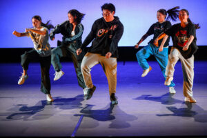 Group of students stomp to the beat on stage