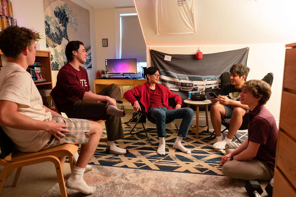 Group of boys sit around dorm room