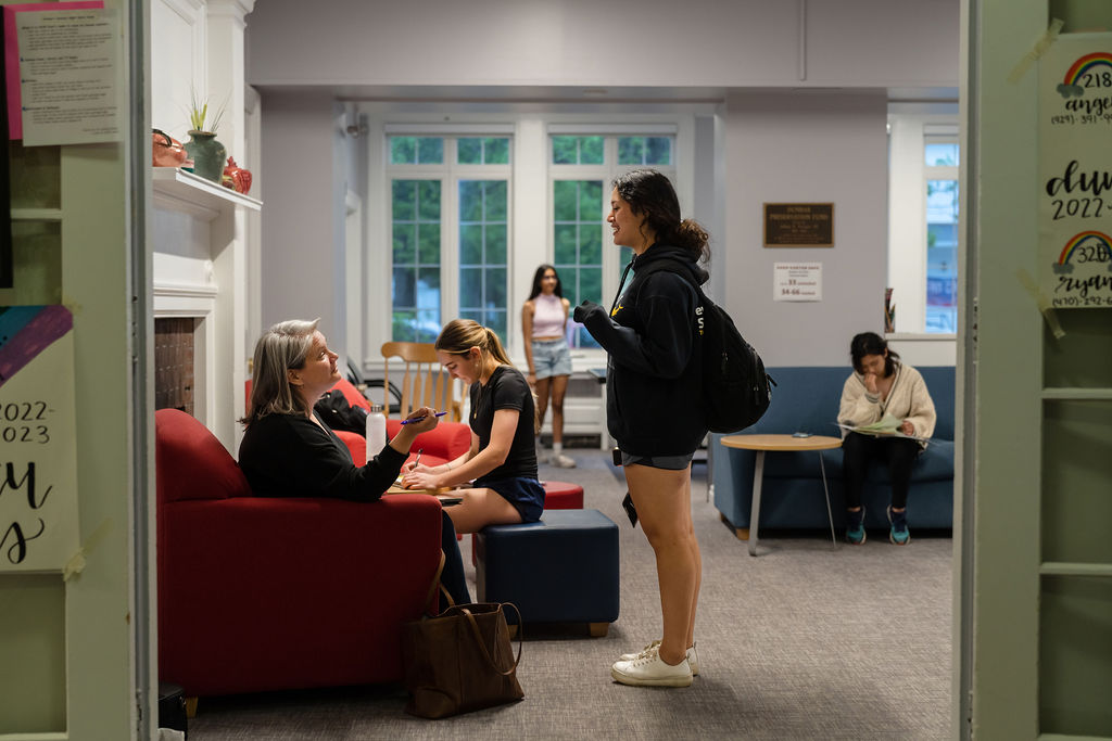 Student talks with teacher in dorm common room