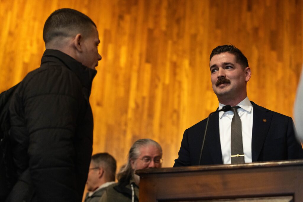 Major Caleb Hoffman Johnson talks with guest on stage.