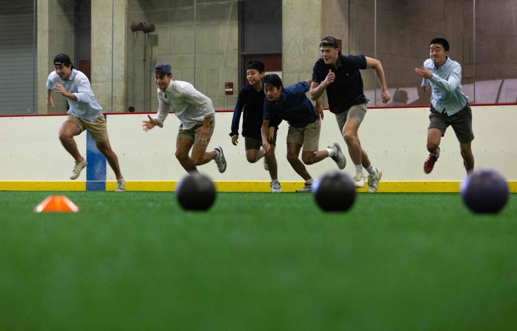 Group of boys running towards the line to start a game of dodgeball.