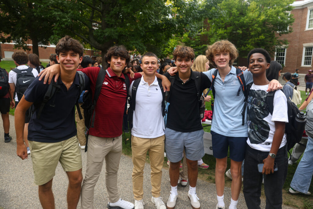 Group of boys standing, smiling, and posing for the camera.