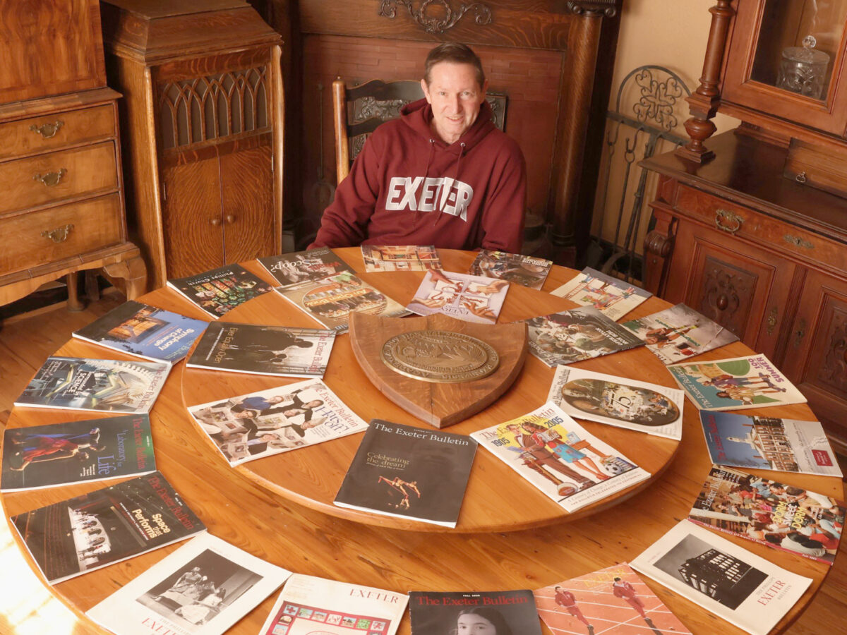 Robert Lutes poses among copies of The Exeter Bulletin.