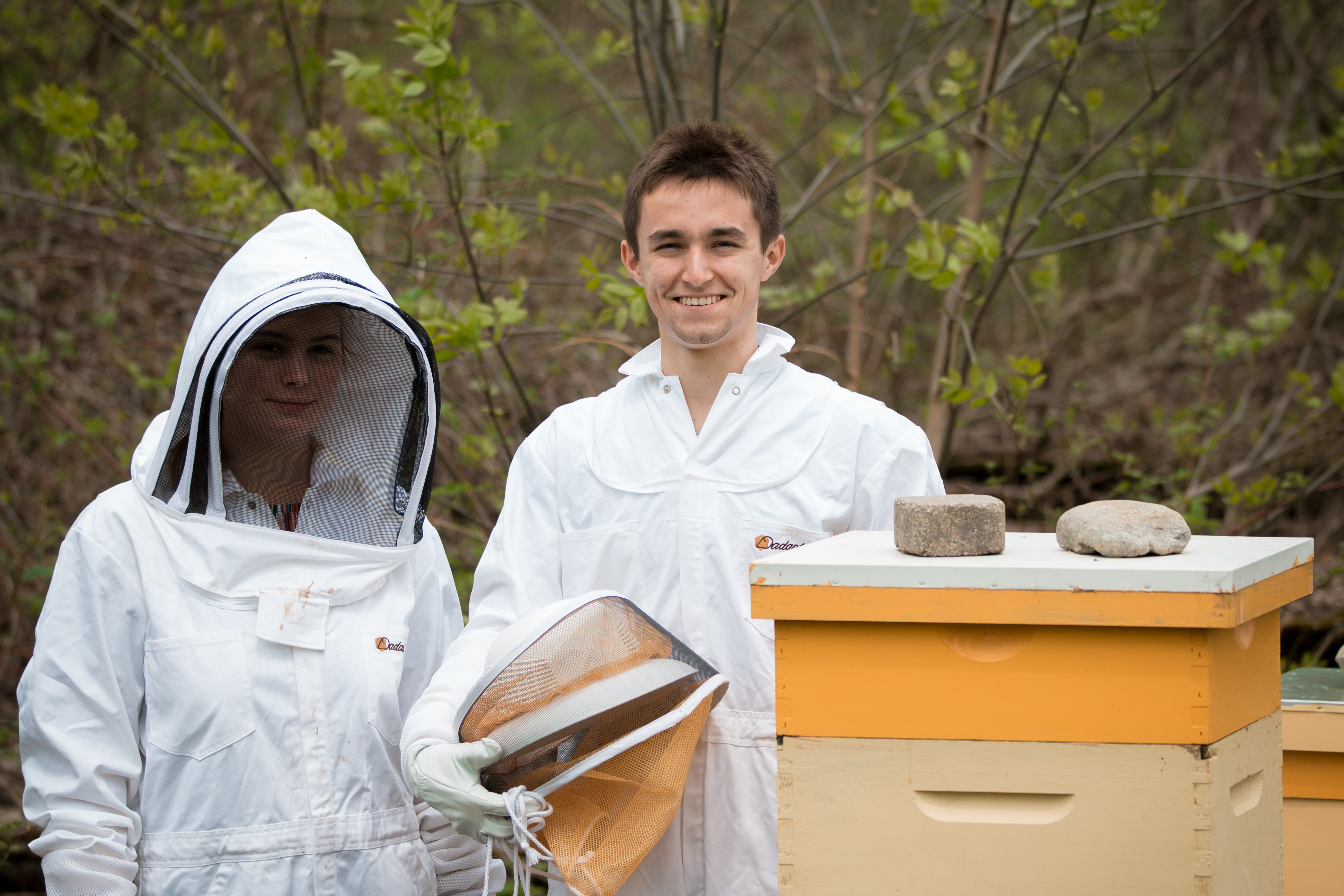 Hannah Johnson '19 and James Fortin' 18 stand beside Exeter's two beehives on South Campus.