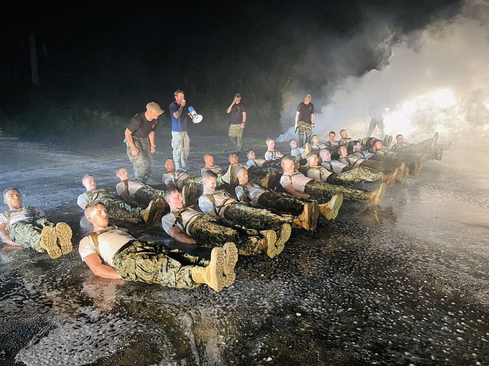 Justin Rigg '23 (front, bottom left) and his fellow Sea Cadets perform flutter kicks during Hell Night of Naval Special Warfare Orientation Course. 