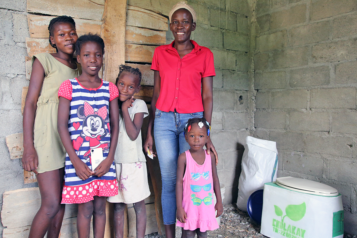 Haitian family with a SOIL toilet in background