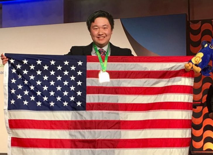 Exeter graduate James Lin a member of the winning team at the 59th International Mathematical Olympiad holding a US flag