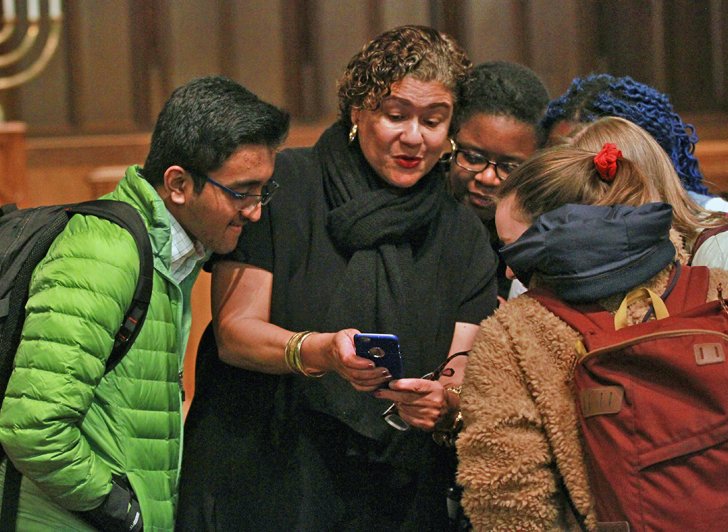 Exeter students gather around poet Elizabeth Alexander as she shows them images from her phone.