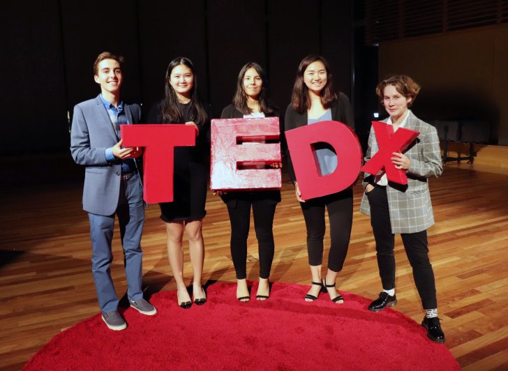 Five Exeter students hold the TEDx logo.