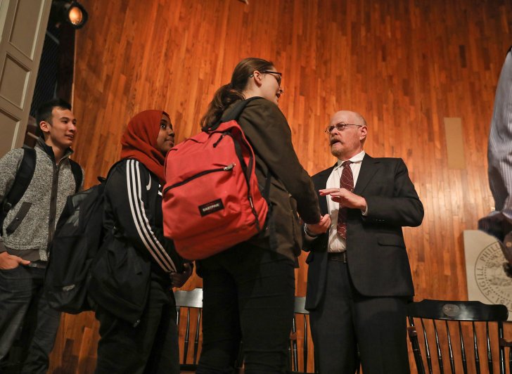 Exeter alumnus Michael Shafer talks with students on Assembly Hall stage.