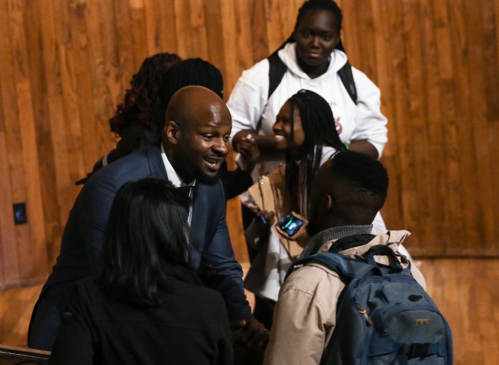 Alex Okosi '94 greets students after delivering his assembly remarks.