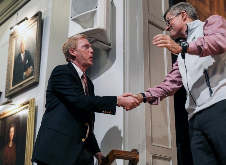 Bill Rawson shakes hands with Trustee Tony Downer in Exeter's Assembly Hall.