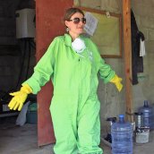 Sasha Kramer in a protective suit, plastic gloves and sunglasses