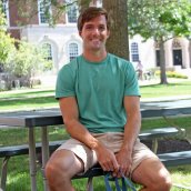 Tyler sitting at a picnic table on campus.