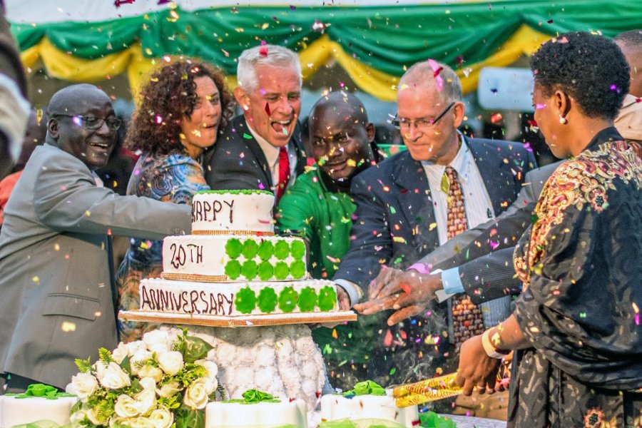 Kevin Bartkovich cuts a birthday cake celebrating the 20th year of a school he helped found.