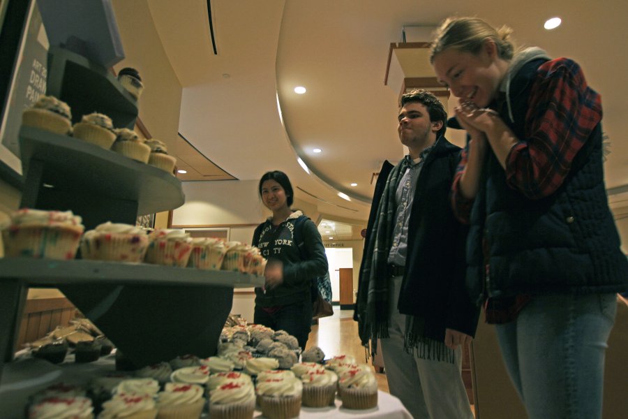 Exeter students choose cupcakes from a table filled with pastry choices