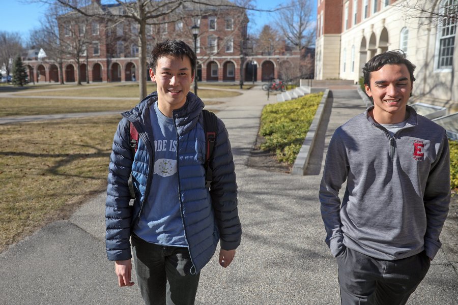 Ben Cai smiling as he walks the paths of Exeter's campus with a friend.