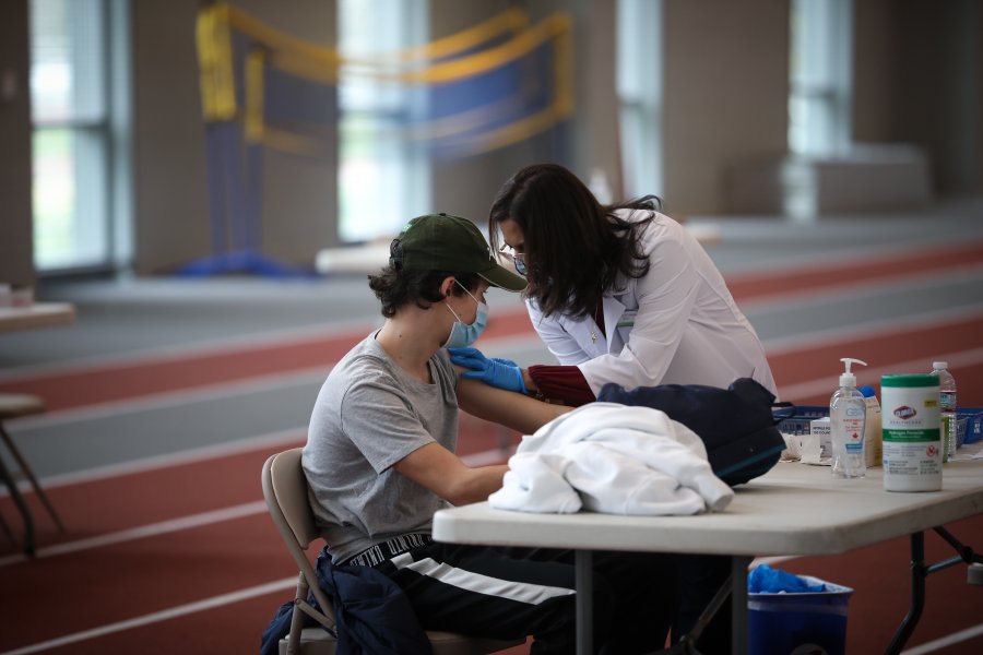 student receiving vaccine in field house