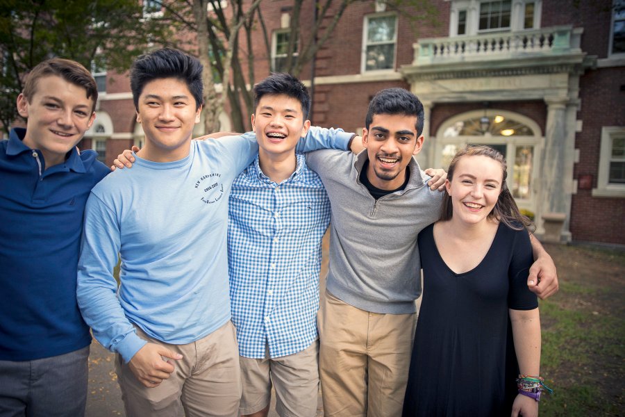 Exeter students outside in the quad, with their arms over each others shoulders.