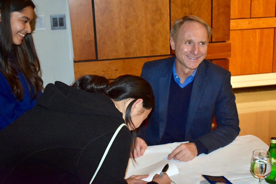 Dan Brown '82 signs books after speaking with the class of 2023. 