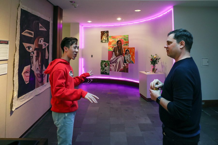 Justin Li and M. Sharkey discuss Li's artwork in the foyer of the Lamont Gallery.
