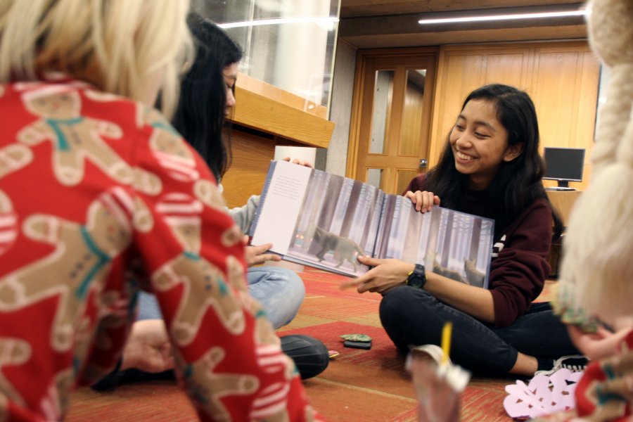 An Exeter students reads The Polar Express to youngsters in the Academy Library.