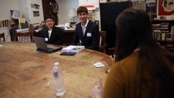 Harrison He '21 (left) and Evan Chandran '21 polish their pitch for a startup with mentor Emma Butler, a senior at Brown University, during the Emerging Entrepreneur Initiative.