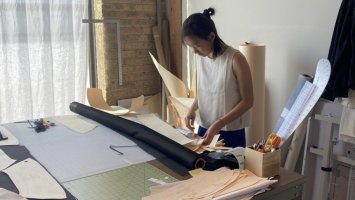 Student cuts fabric during fashion intership