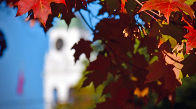 Academy Building bell tower seen through fall foliage. 