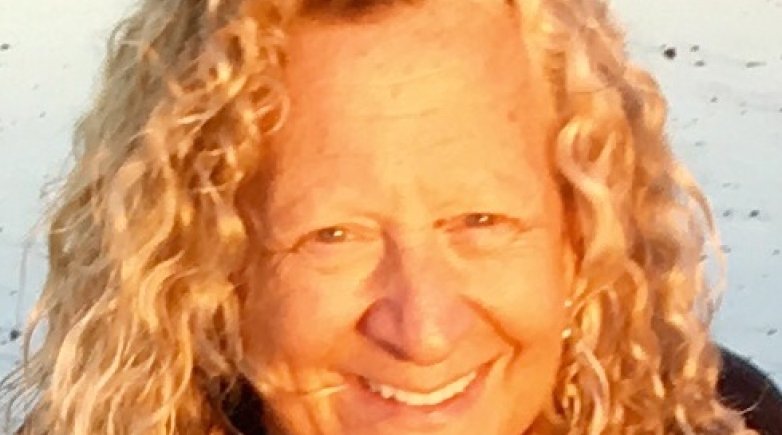 a smiling woman with curly blond hair