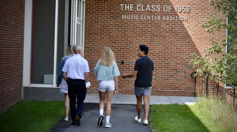 A student guides a prospective family on a tour of campus.
