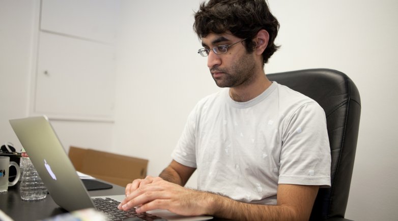 Exeter graduate Kush Patel in front of a computer