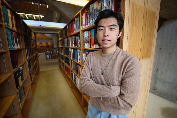 Andrew Yuan '24 standing in Class of 1945 Library