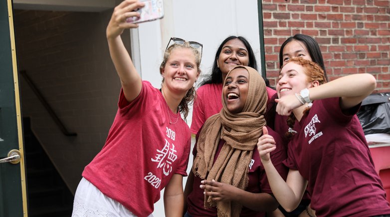 Exeter proctors take a selfie with a new student moving into the dorm. 